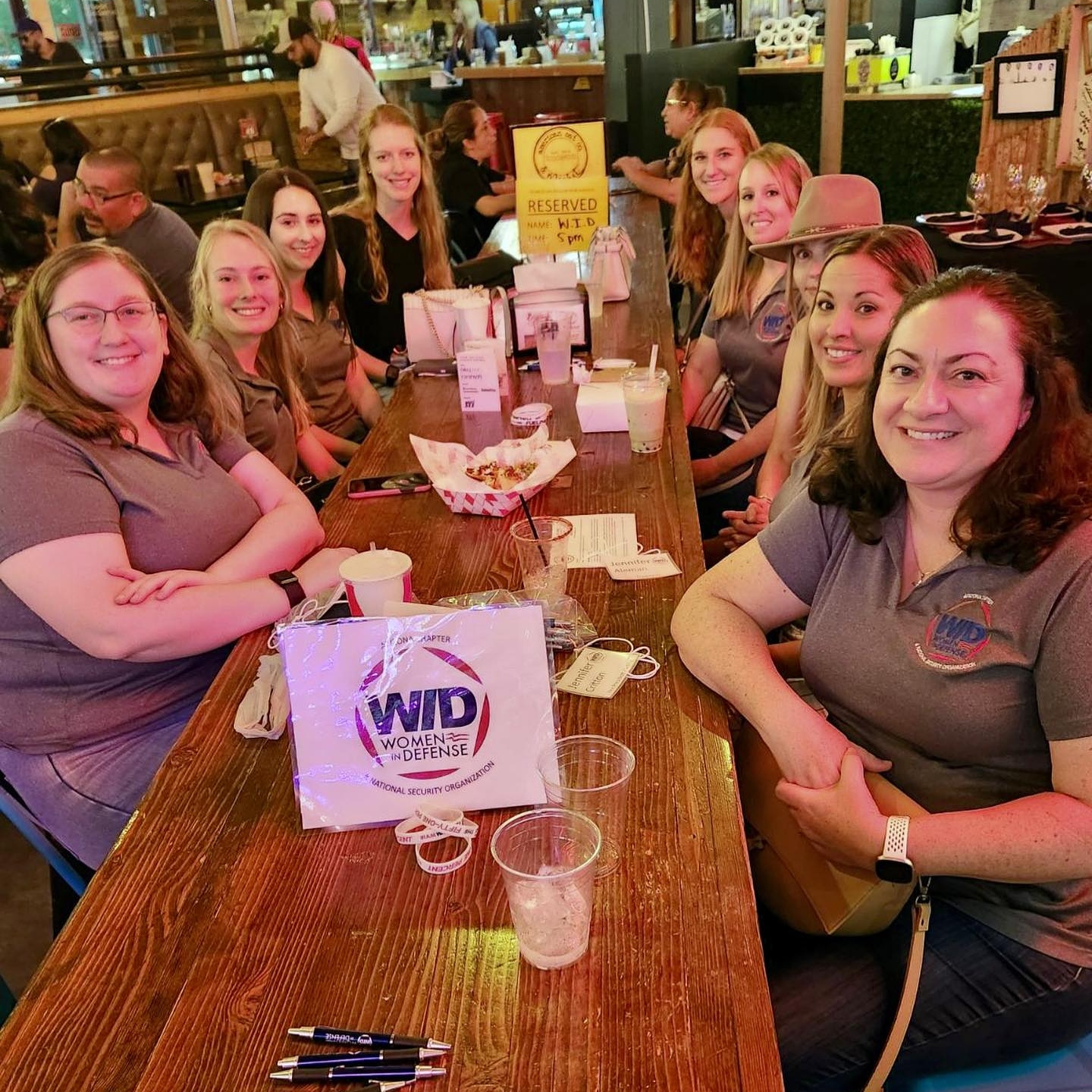 Members of WID Arizona smile around a table as they network